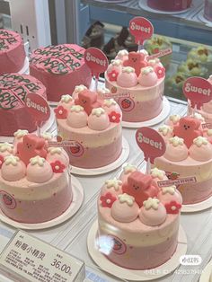 there are many pink cakes on display in the case at this store that is for sale