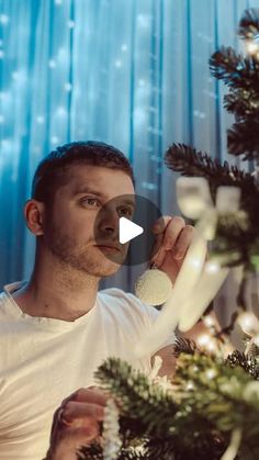 a man is decorating a christmas tree