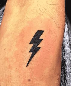 a man's arm with a black lightning tattoo on the left side of his leg