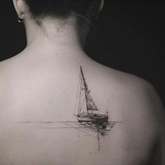 the back of a woman's neck with a sailboat tattoo on it,