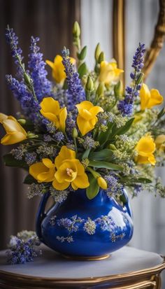 a blue vase filled with yellow and purple flowers