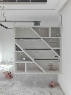 an empty room with white shelves and red bricks on the ground in front of it