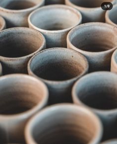 many brown cups are stacked together on the table