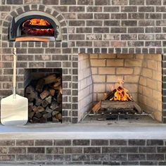 an outdoor brick oven with firewood in it