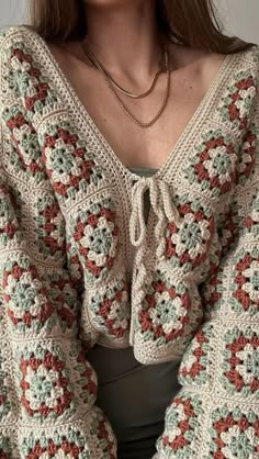 a woman is wearing a crocheted sweater