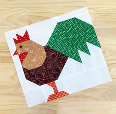 a piece of fabric on top of a wooden table with a rooster and christmas tree