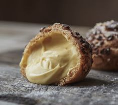 two pastries with cream on them sitting on a table