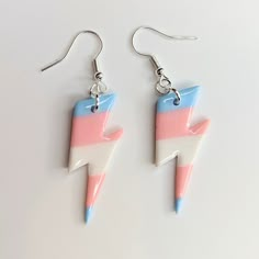 pair of earrings with pink, blue and white lightning bolt