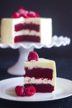 a slice of red velvet cake with white frosting and raspberries