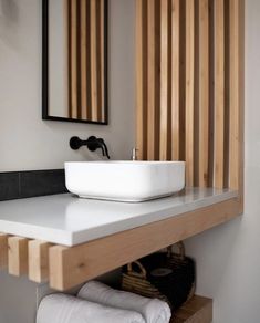 a white sink sitting under a mirror next to a wall mounted faucet in a bathroom