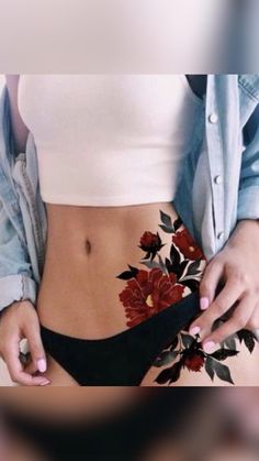 a woman in black panties with flowers on her stomach