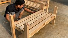 a man kneeling down next to a wooden bench