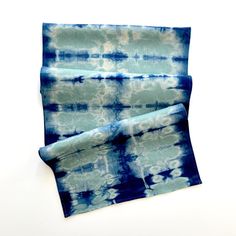 two pieces of blue and white tie - dyed fabric sitting on top of each other