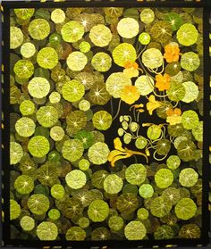 a quilt made with green and yellow leaves on black fabric, featuring an image of water lilies