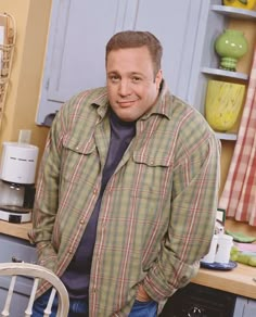 a man standing next to a chair in a kitchen