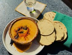 a bowl of soup and some pita bread on a plate