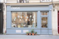 a store front with potted plants in the window