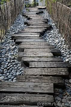 a wooden walkway made out of rocks and wood