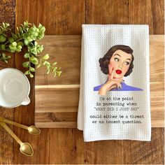 a tea towel with an image of a woman on it next to a cup and spoon