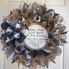 a wreath made out of newspaper strips with a saying on it that says crazy dogs live here do not knock