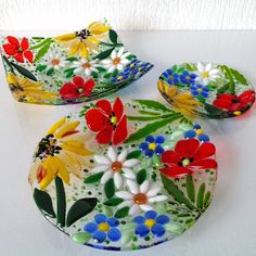 three plates with colorful flowers painted on them