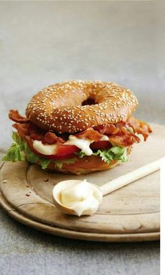 a bagel sandwich with bacon, lettuce and mayonnaise on it