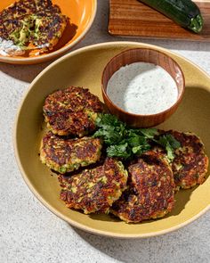 some food is sitting on a plate with a bowl of ranch dressing next to it