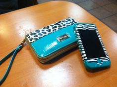 two purses sitting on top of a wooden table next to each other, one with a cell phone in it