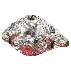 an antique style diamond ring with red accents