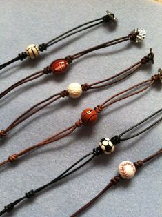 four bracelets with different designs on them sitting on top of a blue cloth covered table