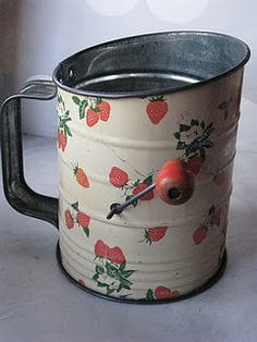 an old tin can with strawberries painted on it and a clock in the middle