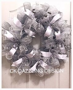 a wreath that is hanging on the front door with ribbon and bowknots