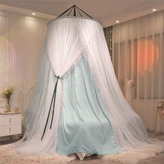 a white canopy bed with blue and white drapes