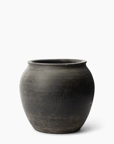 a black vase sitting on top of a white surface