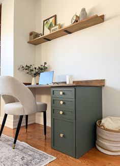 a desk with a laptop on top of it next to a chair