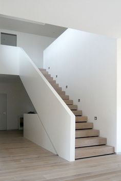 there is a stair case in the middle of this room with white walls and wood floors