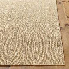 a beige rug is on the floor with wooden floors and wood planks in the background