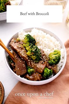 a bowl filled with rice, broccoli and beef next to chopsticks