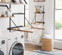 a washer and dryer in a room with open shelving on the wall