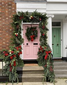 two wreaths on the front steps of a house decorated for christmas