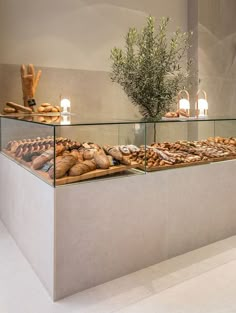 a display case filled with lots of different types of breads and pastries on top of glass shelves