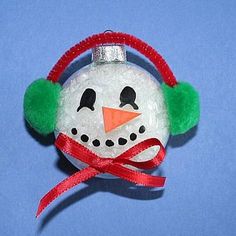 a snowman ornament with headphones and a red ribbon around its neck