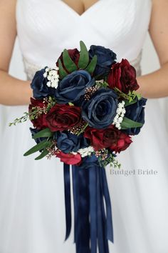 a bridal bouquet with red, white and blue flowers is held by a bride