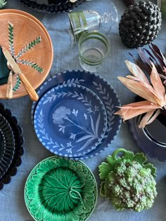 many plates are arranged on a table with pine cones