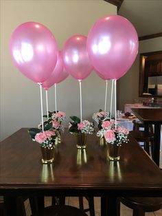 three vases filled with pink flowers and balloons