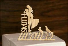 a wooden cake topper with the words, mom's and two dogs