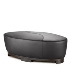 a grey leather ottoman sitting on top of a wooden base