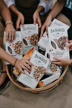 several people holding boxes of food in front of each other on the ground with their hands