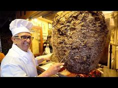 a man in a chef's hat holding up a large piece of meat