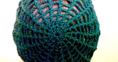 a close up view of the back of a person's head wearing a green crocheted hat